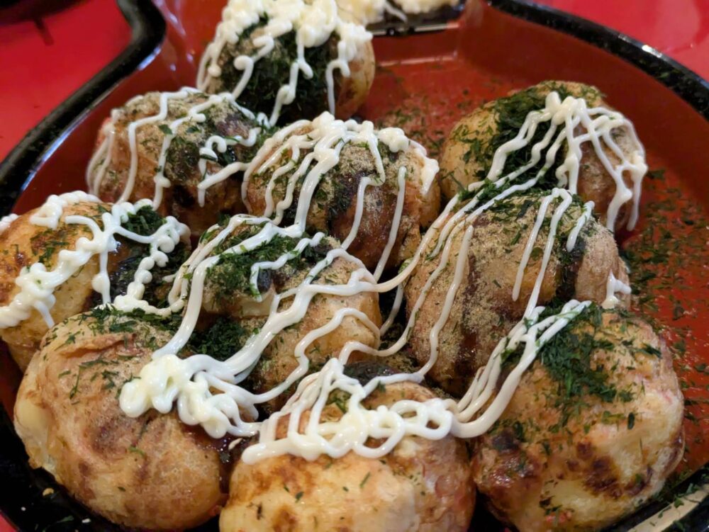 和楽路屋のたこ焼きにお好み焼きや青のりをかける