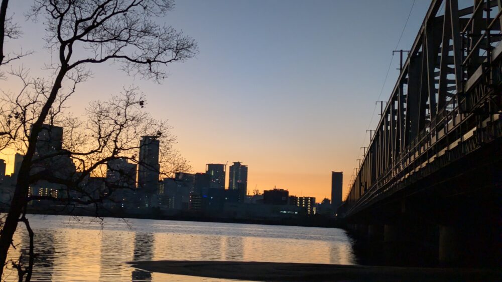 早朝の淀川河川敷から朝焼けに染まる大阪市街を堪能