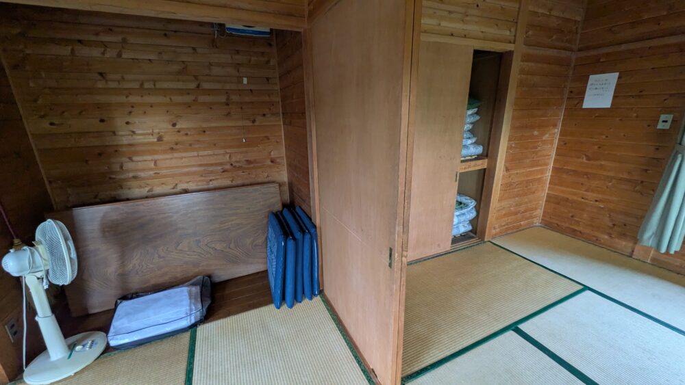 乙女森林公園第一キャンプ場のバンガローのテーブルと布団